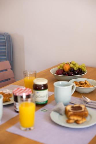 a table with a plate of food and a bowl of fruit at Okeanos Suites 3, Sea & Garden View in Foinikiá