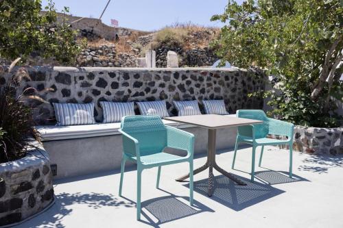 three chairs and a table on a patio with a bench at Okeanos Suites 3, Sea & Garden View in Foinikiá