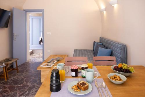a wooden table with breakfast foods and drinks on it at Okeanos Suites 3, Sea & Garden View in Foinikiá