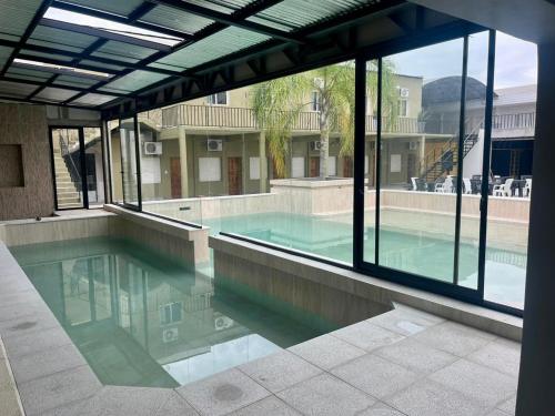 a swimming pool in a building with glass windows at Hotel Mar Del Plata in Termas de Río Hondo