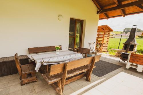 a patio with a table and benches and a fireplace at Domčeky Sabinka a Melinka in Valča