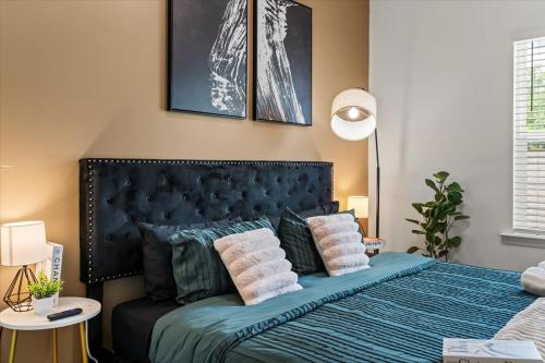 - une chambre avec un lit bleu et des oreillers dans l'établissement Luxe King 3BR Townhouse Mins to Uptown Charlotte!, à Charlotte