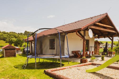 a house with a swing in a yard at Domčeky Sabinka a Melinka in Valča