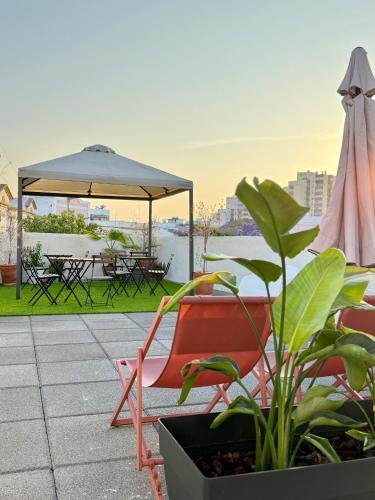 a patio with a chair and an umbrella and a table at Casa Sebastião in Faro