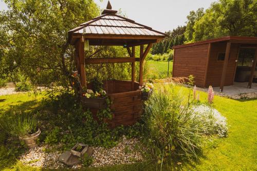 a wooden gazebo in the middle of a garden at Domčeky Sabinka a Melinka in Valča