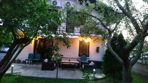 a patio in front of a house with blue chairs at Kuca za odmor Amber in Bihać