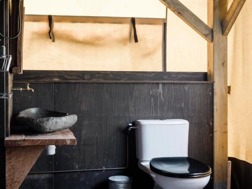een badkamer met toilet en wastafel bij Charming Woodlodge Stay in Callantsoog