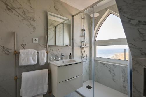 a white bathroom with a sink and a shower at Casal Santa Virginia in Sintra