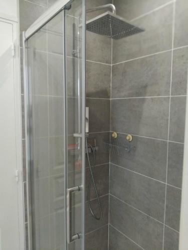 une douche avec une porte vitrée dans une salle de bain dans l'établissement Peace, à Nanterre