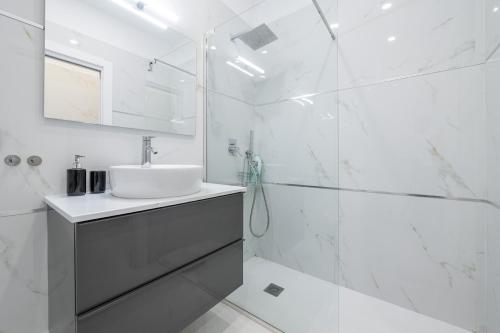 a white bathroom with a sink and a shower at Loft Eleonora D’Arborea in Quartu SantʼElena