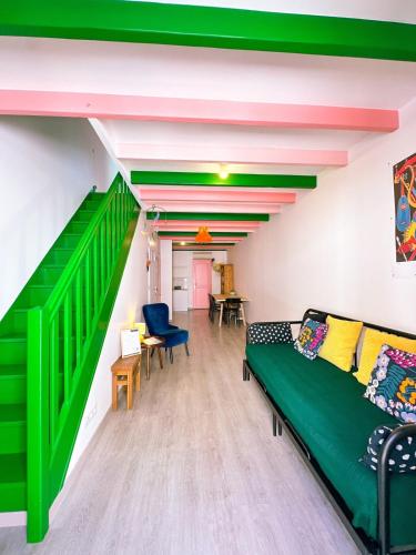 - un salon avec un canapé vert et un escalier dans l'établissement Rosa Verde, à Sète
