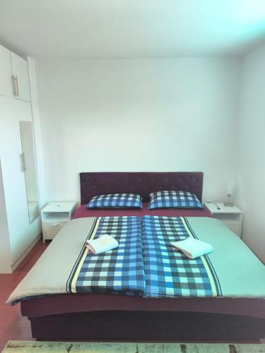 a bed with two pillows and a blanket on it at Apartments Amina Sarajevo in Sarajevo