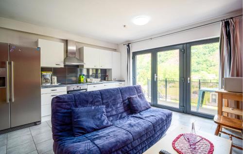 un salon avec un canapé bleu dans une cuisine dans l'établissement Appartement Vue Sur La Meuse, à Chooz