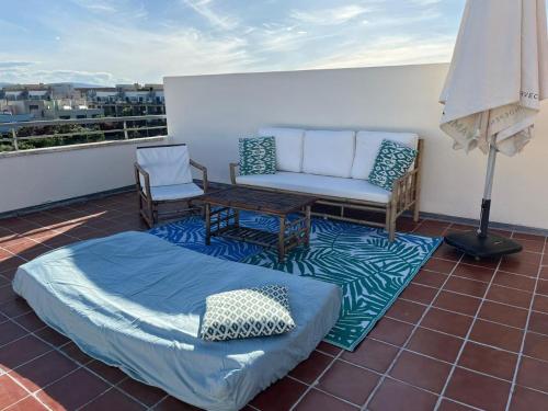 un patio con sofá y una mesa en el techo en Ático Premium con Azotea, Pádel y Piscina, en Sant Jordi (San Jorge)