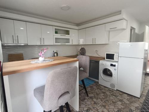 a kitchen with a counter with chairs and a refrigerator at Apartments Amina Sarajevo in Sarajevo