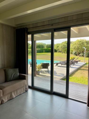 - un salon avec des portes coulissantes en verre donnant sur une terrasse dans l'établissement Apartments PETIT DOMAIN DE SPERONE, à Bonifacio
