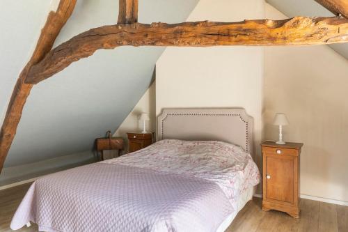 a bedroom with a bed and a wooden beam at Sweet cottage 1 hr 40 min from Paris in Béthonvilliers