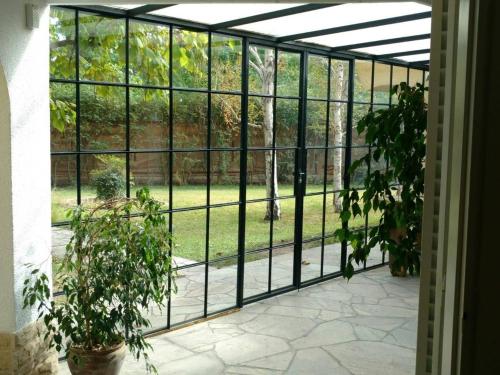 an internal view of a glass greenhouse with plants at La Masia in Chacras de Coria