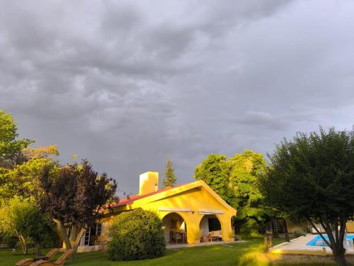 a yellow house with a pool in a yard at La Masia in Chacras de Coria