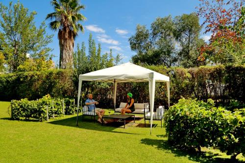 two people sitting in a gazebo in a garden at La Masia in Chacras de Coria