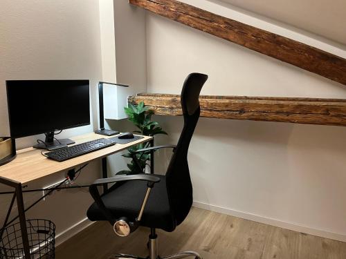 an office with a desk with a computer and a chair at BEYOND Staying Apartments Passau in Passau