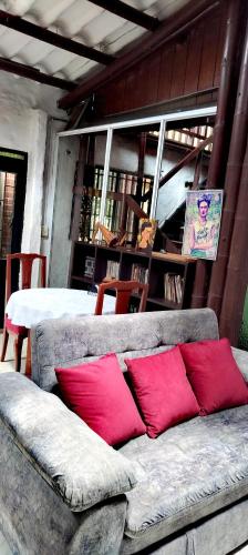 two red pillows sitting on a couch in front of a table at El susurro del agua exclusiva - natural in Ibagué