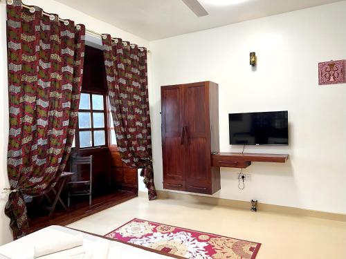 a living room with a flat screen tv and a living room at Treasures of Zanzibar House in Zanzibar City