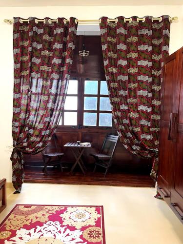 a room with a window with curtains and a rug at Treasures of Zanzibar House in Zanzibar City
