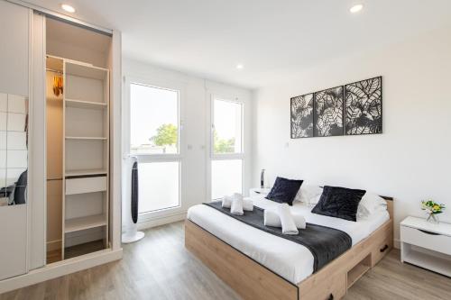 a bedroom with a large bed and two windows at Large 4 Bedroom Apartment near metro - only 30 minutes to Paris and Disneyland in Créteil