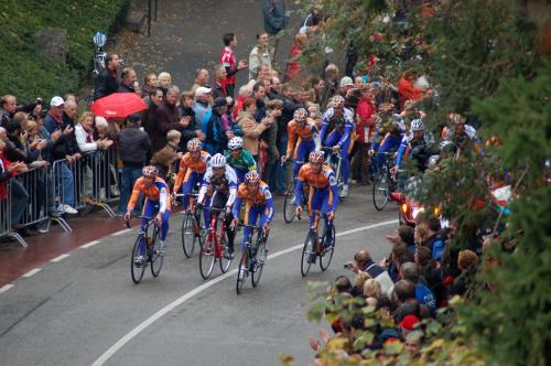 a group of people riding bikes down a road in front of a crowd at Huis Ter Geul in Valkenburg