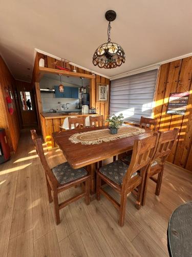 a dining room with a wooden table and chairs at Hermosa Cábaña algarrobo a pasos de la playa in Algarrobo