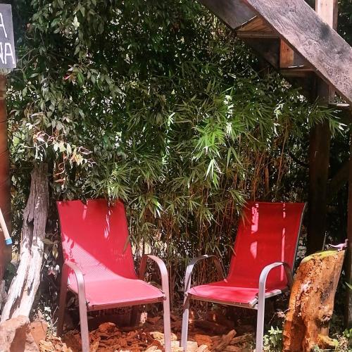 two red chairs sitting in front of a tree at Cabaña en la Calera BersaNina in La Calera