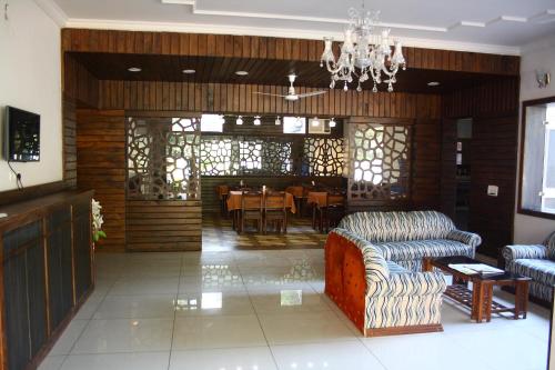 a living room with couches and a dining room at Hotel Moksha in Rishīkesh