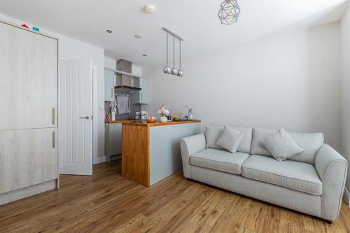 a living room with a couch and a kitchen at 7-Min Walk to Principality and City Centre in Cardiff