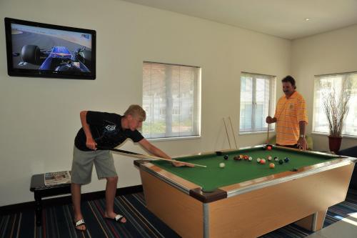 two men playing a game of pool in a room at Premier Splendid Inn Bayshore in Richards Bay
