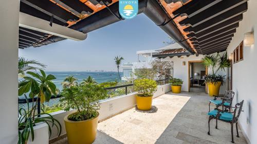 a balcony with plants and a view of the ocean at Casa Bahía Linda by Kivoya in Puerto Vallarta