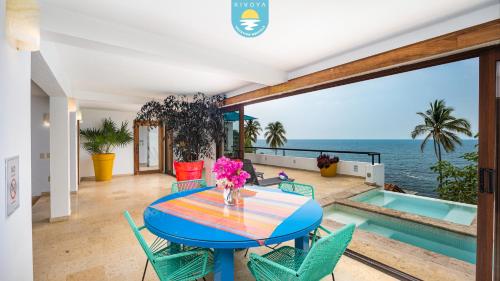 a dining room with a table and chairs and the ocean at Casa Bahía Linda by Kivoya in Puerto Vallarta