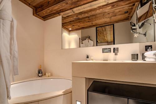 a bathroom with a bath tub and a sink and a bath tub at Stylish 3BR Apartment with Mountain View - 8 Guests, Rochebrune, Megève in Megève