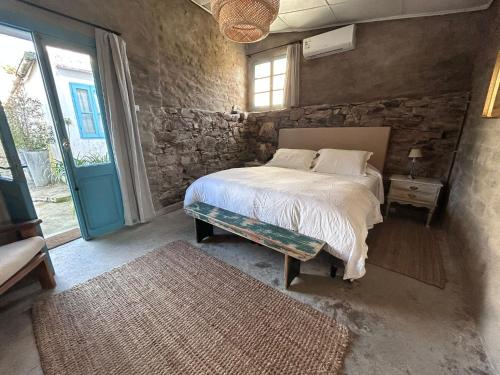 una camera da letto con un letto e un muro di pietra di Loft de Campo en las sierras de Mariscala a Mariscala