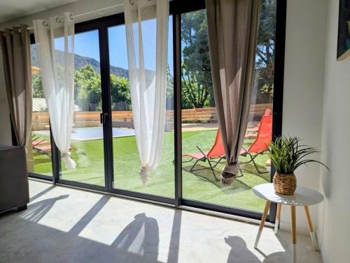 Cette chambre dispose de portes coulissantes en verre offrant une vue sur la cour. dans l'établissement Villa Maëva, Idéal pour familles et groupes, à Pierrelongue