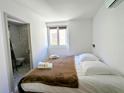 une chambre avec un grand lit avec deux serviettes dessus dans l'établissement Villa Maëva, Idéal pour familles et groupes, à Pierrelongue