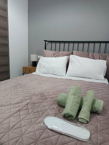a bed with two green pillows and a tray on it at Heraklion Central Studio MaZa1 in Néa Alikarnassós