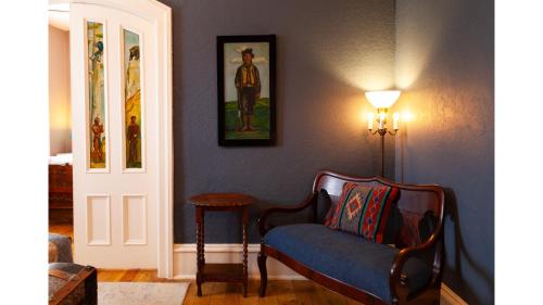 un soggiorno con sedia blu e lampada di Wyatt Earp - Historic Hotel a Cimarron