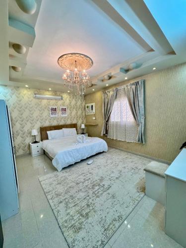een slaapkamer met een groot wit bed en een kroonluchter bij نورة ريزيدينس in Taif