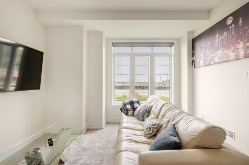 a living room with a couch and a window at The Residence, Your comfort is our culture in Oakville