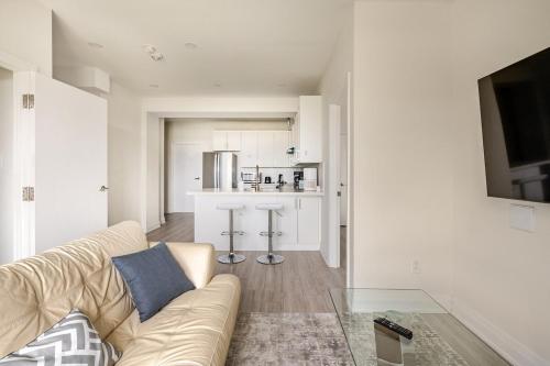 a living room with a couch and a kitchen at The Residence, Your comfort is our culture in Oakville