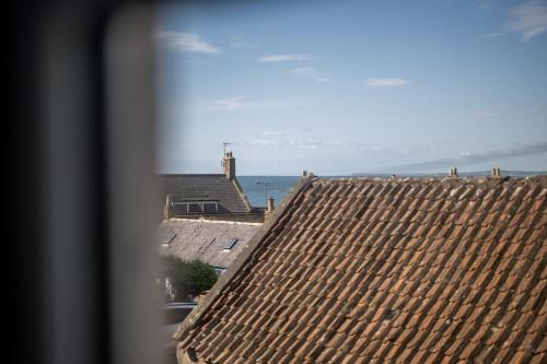 a view from a window of a roof at Kewwater Getaways Seafront Apartment in Johnshaven in Johnshaven