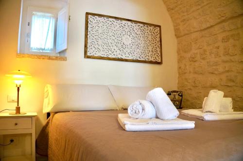 Un dormitorio con una cama con toallas. en Villa Filippo Relax & Nature - Puglia Mia Apartments, en Selva di Fasano