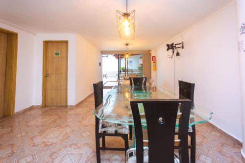 a dining room with a glass table and chairs at Hotel Colores Boutique in Medellín