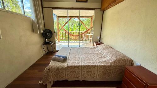 a bedroom with a bed and a large window at Casa Gringa in Cavalcante